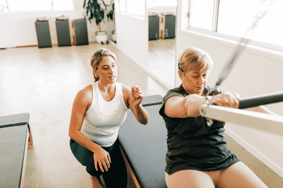 Instructor Helping Pilates Student — Pilates Studio In Albany Creek, QLD