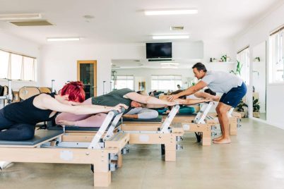 Trainer Teaching Students on Pilates Studio Reformer — Pilates Studio In Albany Creek, QLD